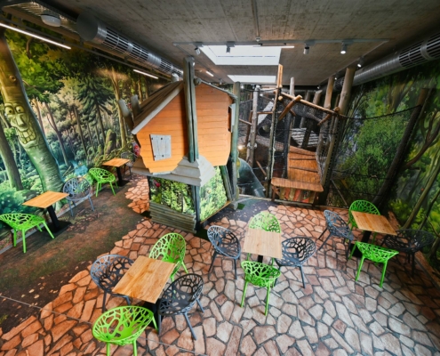 Spielbereich und Cafeteria mit Fotoboden mit Pflastermotiv und Waldboden